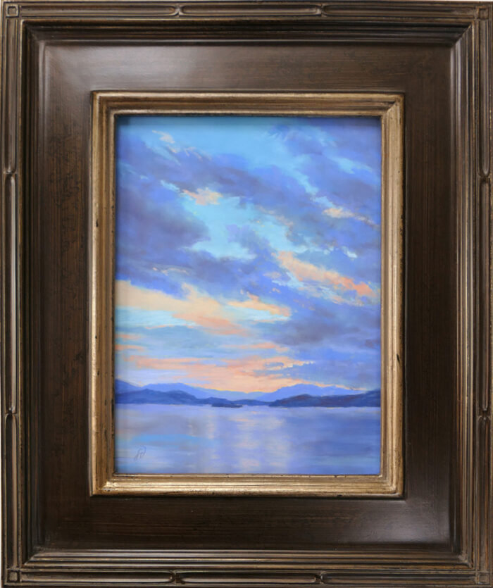 Pastel painting of a sunset over Big Arm on Flathead Lake, Montana, in a frame.