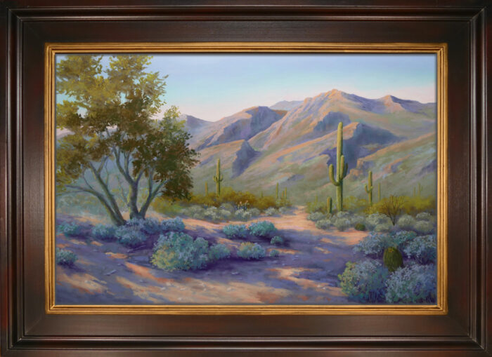 A pastel painting of the desert landscape of Sabino Canyon in Tucson with brown wood and gold inset frame.