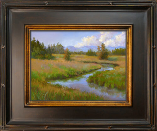 Photo of a pastel painting of a landscape in the Flathead Valley with black and gold frame.