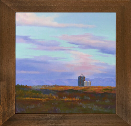 Photo of a pastel painting of silos in a field during sunrise with brown frame.