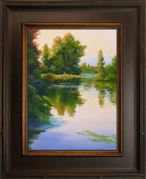 Photo of a framed pastel painting of water and warm tones on the trees behind.