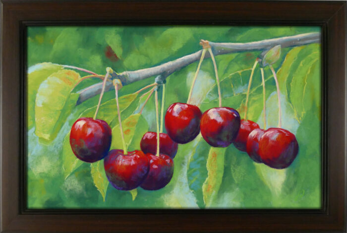 An original pastel painting of cherries hanging on a branch framed.