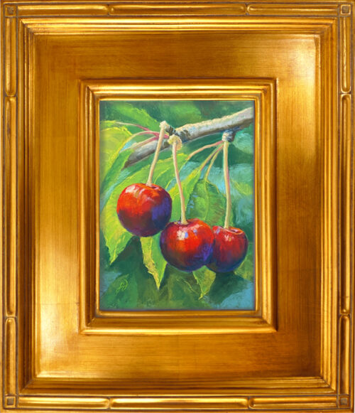 A pastel painting of three cherries hanging on a branch in a gold frame.