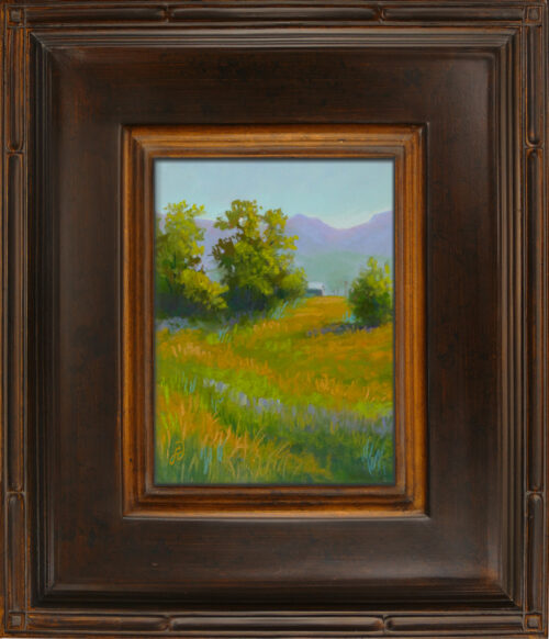 A photo of a framed pastel painting of a rural scene in Montana.